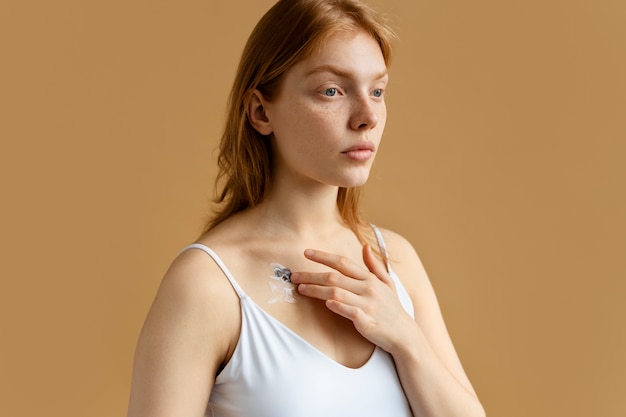 Medium shot woman applying cream on mole