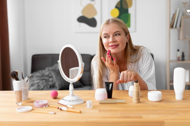 Medium shot woman applying face cream