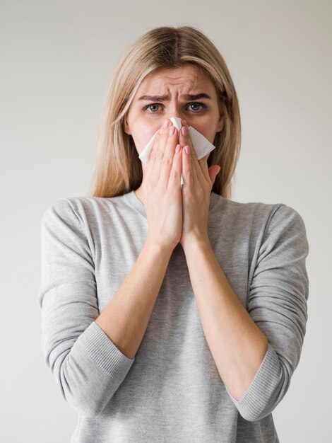 Medium shot woman blowing nose