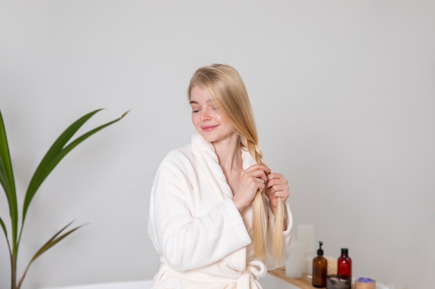 Free photo medium shot woman braiding her hair