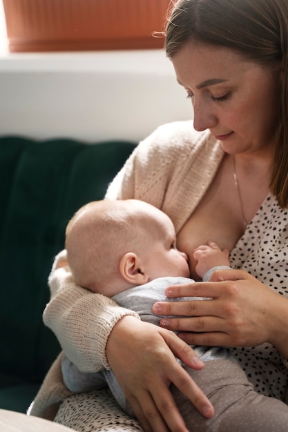 중간 샷 여성 모유 수유 아기