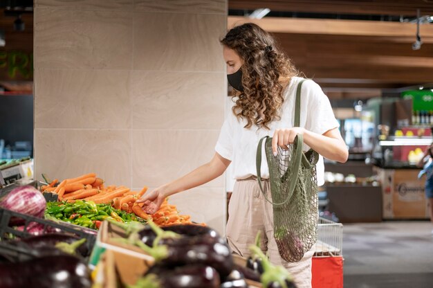 Medium shot woman buying vegetables