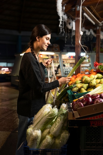Женщина среднего роста покупает овощи