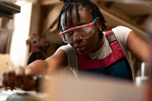 Medium shot woman carpenter with goggles