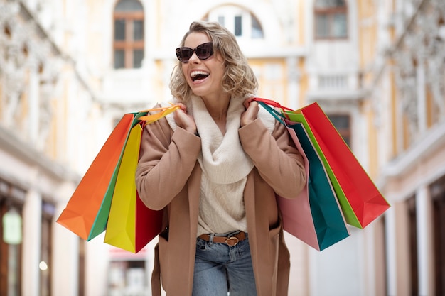 Medium shot woman carrying bags