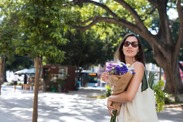 Free photo medium shot woman carrying bouquet