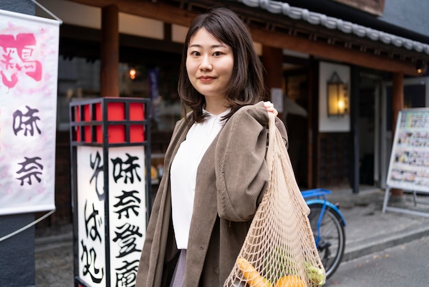 medium shot woman carrying fabric bag