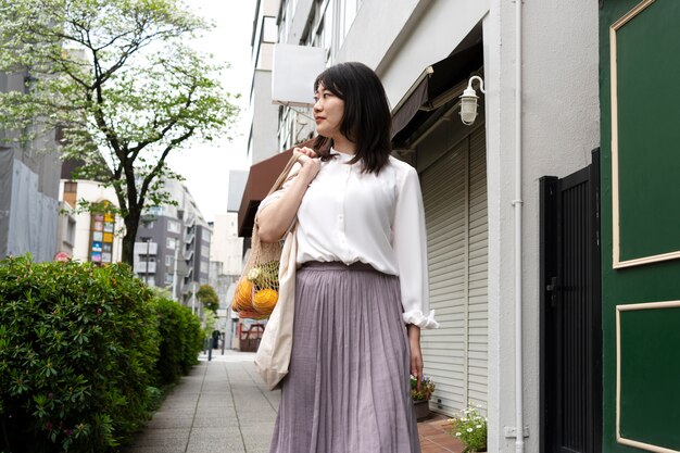 Medium shot woman carrying tote bag