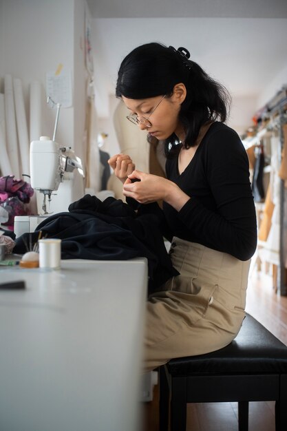 Medium shot woman on chair sewing