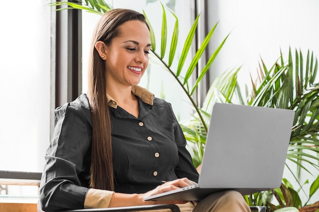 Medium shot woman checking statistics on laptop