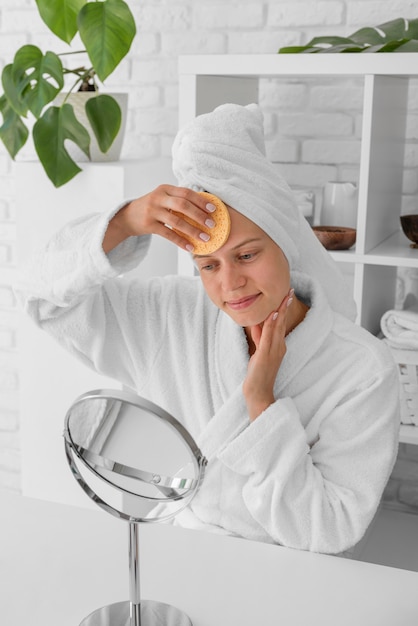 Free photo medium shot woman cleaning face