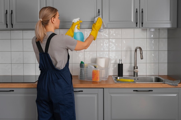 Foto gratuita donna del colpo medio che pulisce casa