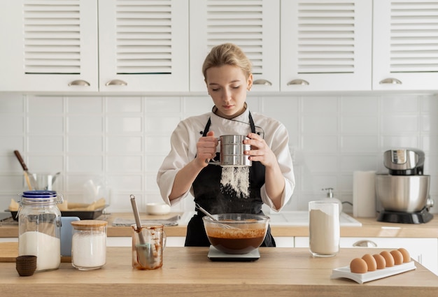 Foto gratuita donna del colpo medio che cucina nella cucina