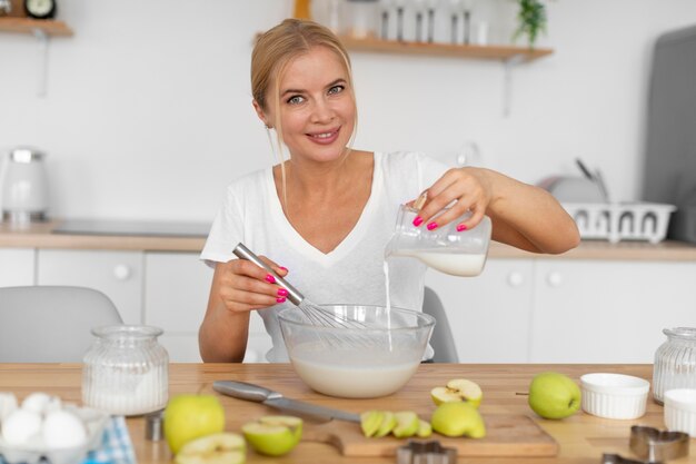 ミルクで料理するミディアムショットの女性