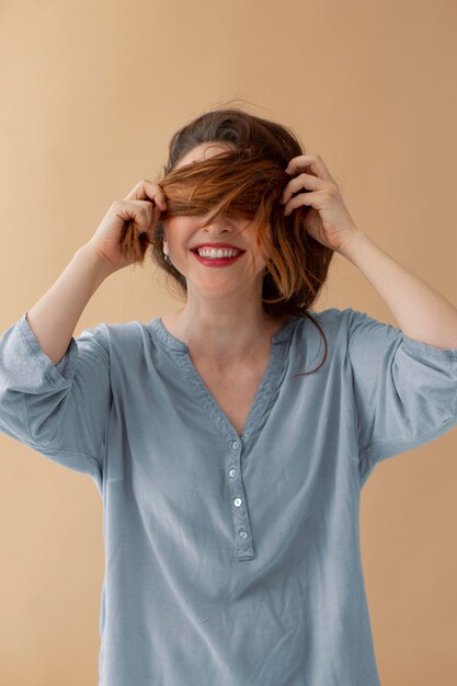 Medium shot woman covering eyes with hair