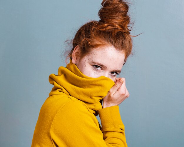 Medium shot woman covering her face with hoodie