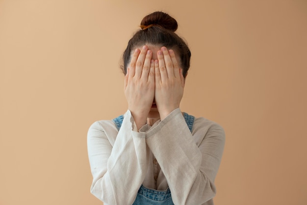 Free photo medium shot woman covering her face