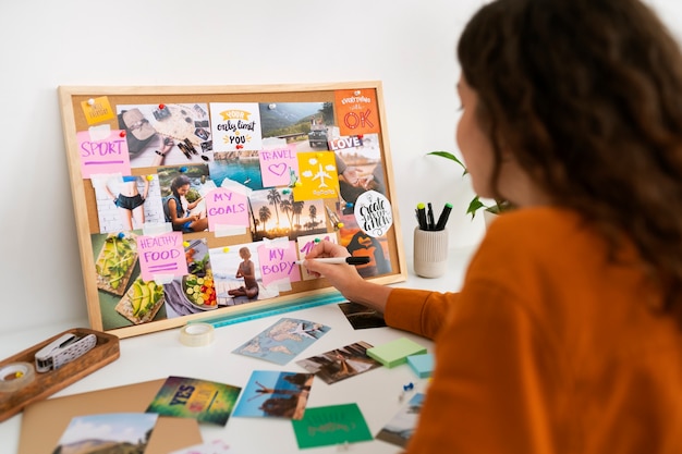 Free Photo  Woman creating inspiring vision board high angle