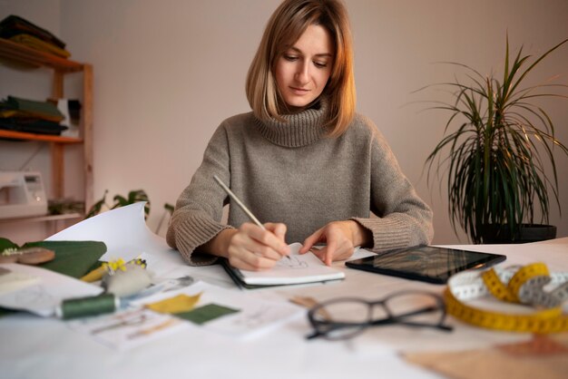 Foto gratuita donna del colpo medio che crea la scheda di visione