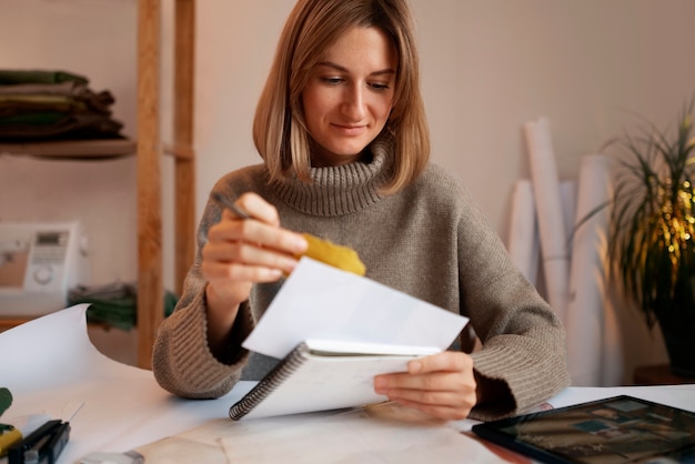 Foto gratuita donna del colpo medio che crea la scheda di visione