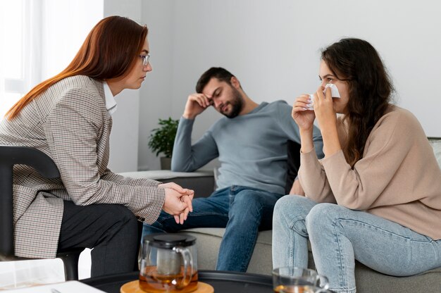 Medium shot woman crying at therapy