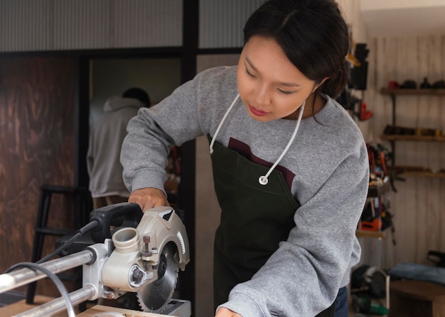 Free photo medium shot woman cutting wood