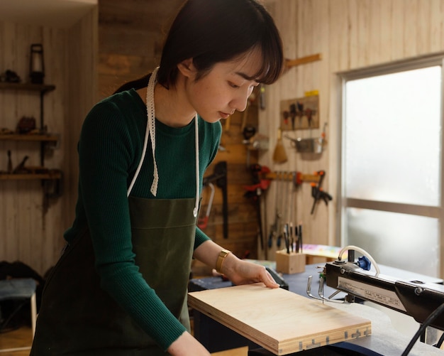 Free photo medium shot woman cutting wood