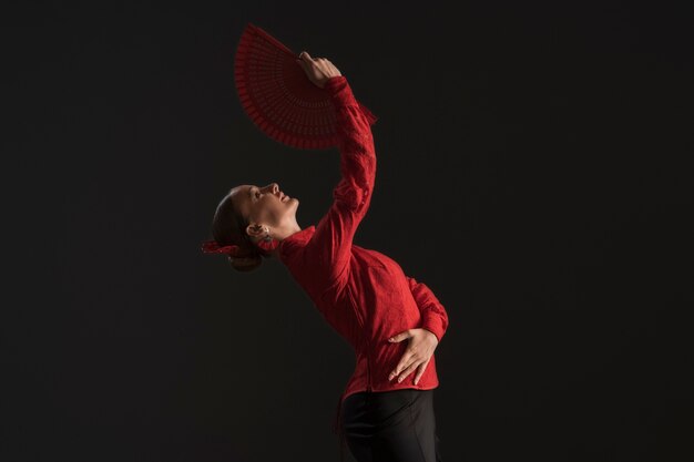 Free photo medium shot woman dancing with fan