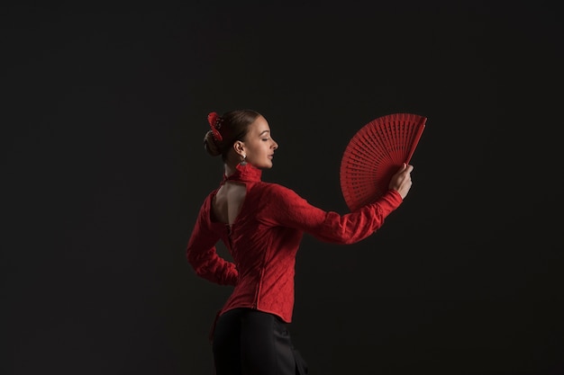 Medium shot woman dancing with fan