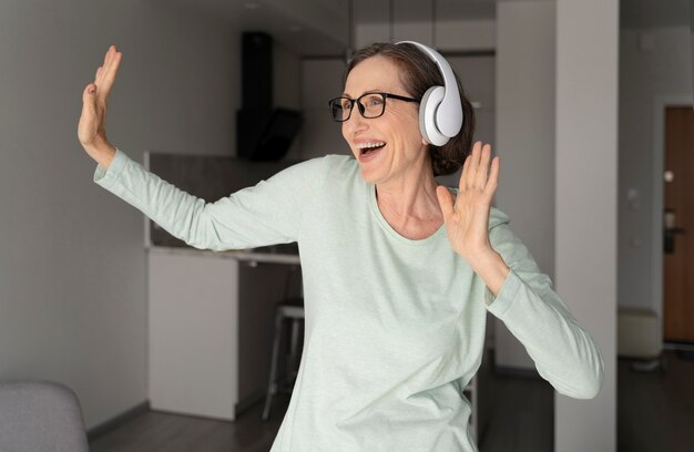 Medium shot woman dancing with headphones