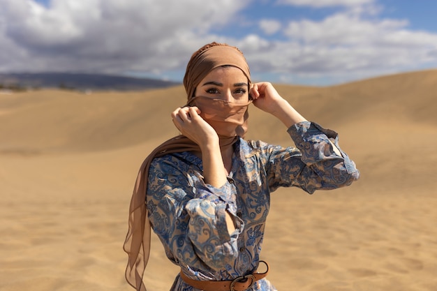 スカーフと砂漠のミディアムショットの女性