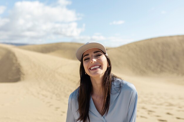 Medium shot woman in desert with trucker hat