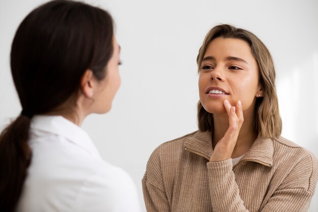 Medium shot woman and doctor at clinic