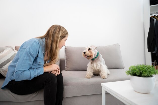 Medium shot woman and dog on couch