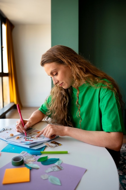 Medium shot woman doing creative journaling