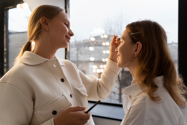 Free photo medium shot woman doing make up