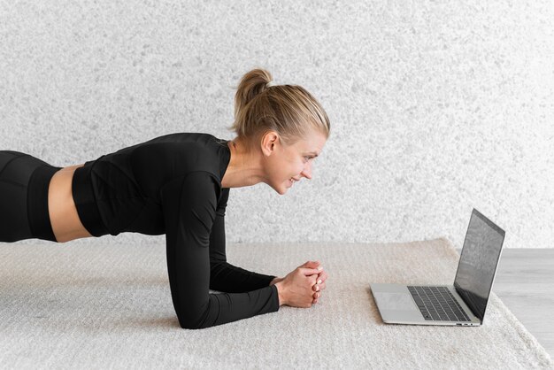 Medium shot woman doing plank