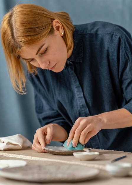 Medium shot woman doing pottery