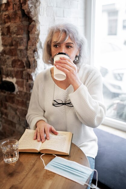 Женщина среднего роста пьет кофе