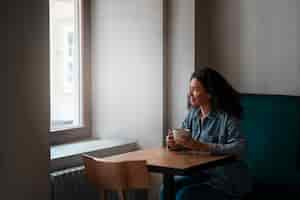 무료 사진 커피를 마시는 중간 샷 여자