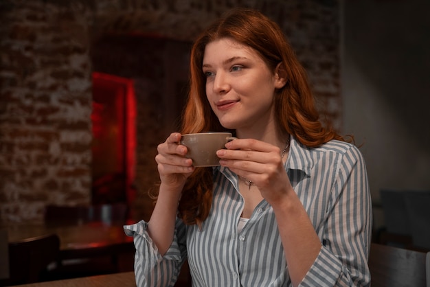 無料写真 ミディアムショットの女性がコーヒーを飲む