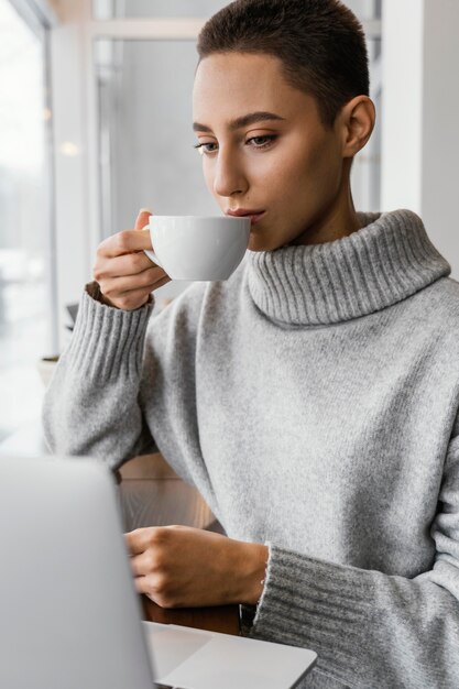 Medium shot woman drinking from cup