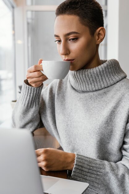 medium shot woman drinking from cup