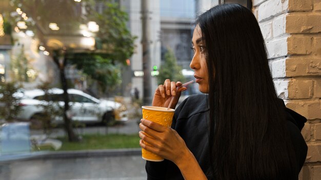 Foto gratuita colpo medio donna che beve succo di frutta