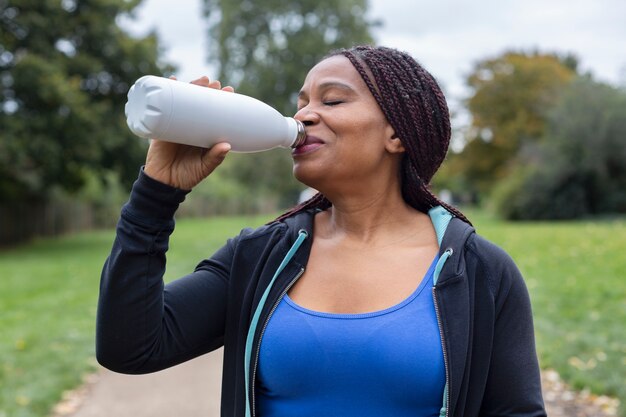 Medium shot woman drinking water