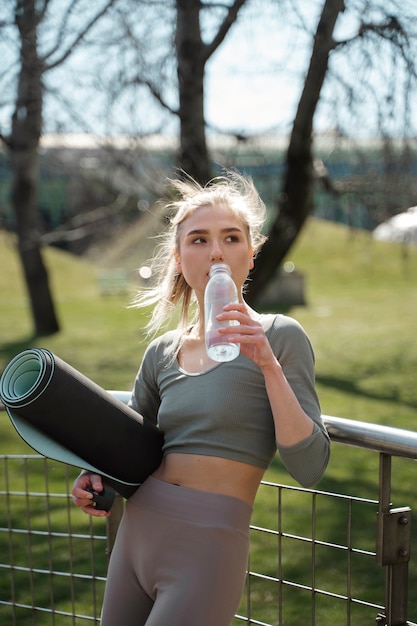 Medium shot woman drinking water