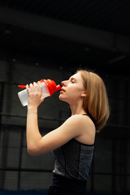 Medium shot woman drinking water