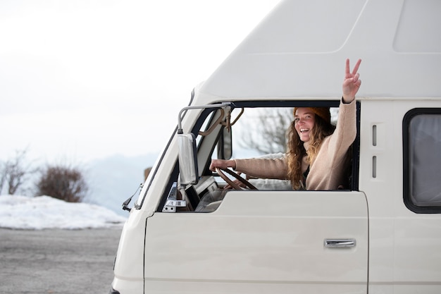 Free photo medium shot woman driving campervan