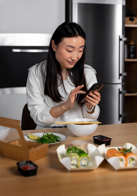 Free photo medium shot woman eating asian food