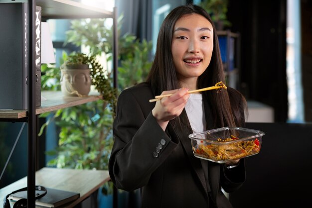 아시아 음식을 먹는 중간 샷 여자